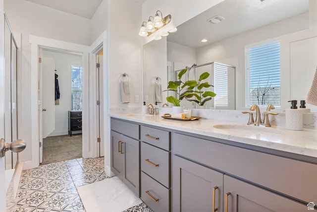 full bath with double vanity, tile patterned floors, a sink, and a shower stall