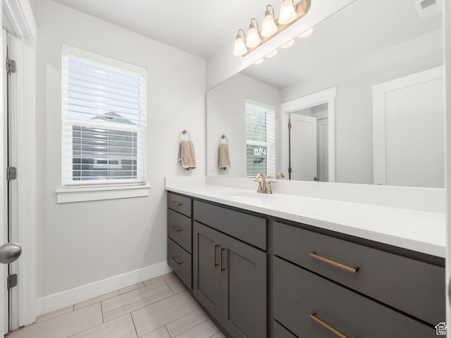 bathroom featuring visible vents, vanity, and baseboards