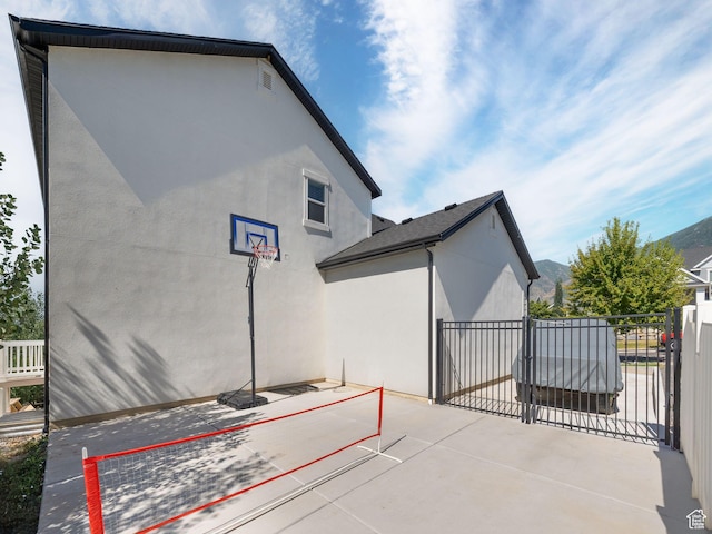exterior space featuring a gate, fence, and stucco siding