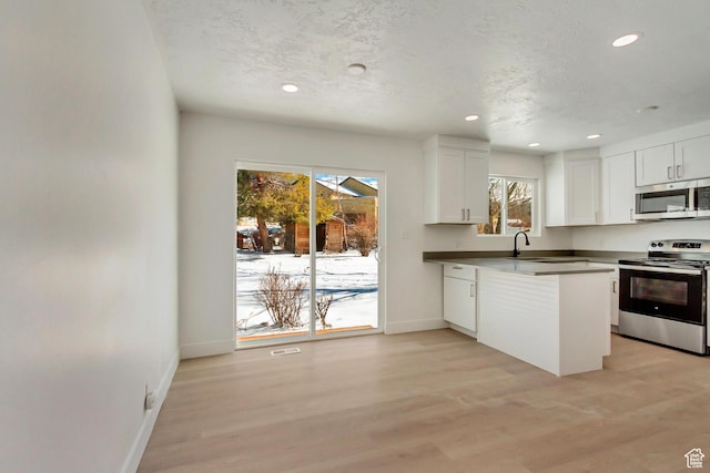 320 S 7 E, Tooele, UT 84074 - kitchen featuring stainless steel appliances, baseboards, white cabinets, light wood-type flooring, and recessed lighting