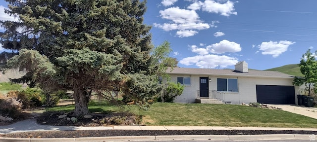 320 S 7 E, Tooele, UT 84074 - view of front of home with an attached garage, a front yard, a chimney, concrete driveway, and brick siding