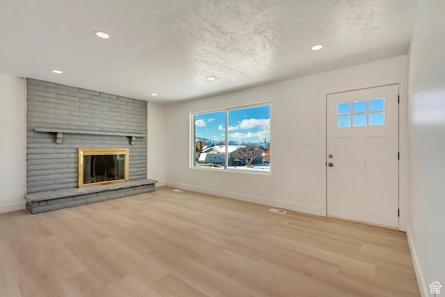 320 S 7 E, Tooele, UT 84074 - unfurnished living room with baseboards, wood finished floors, recessed lighting, a fireplace, and a textured ceiling