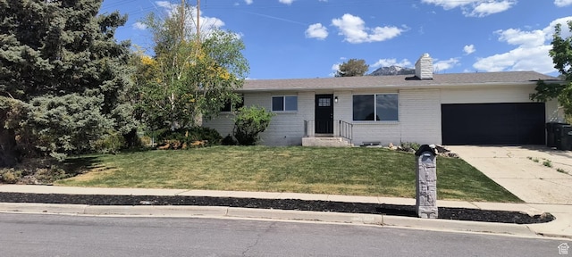320 S 7 E, Tooele, UT 84074 - ranch-style house with an attached garage, concrete driveway, a front lawn, a chimney, and brick siding