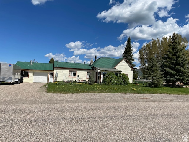 114 4th, Georgetown, ID 83239 - view of front of house with an attached garage, metal roof, dirt driveway, and a chimney