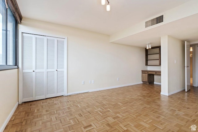 241 N Vine St Unit 1201E, Salt Lake City, UT 84103 - unfurnished bedroom with built in desk, a closet, and light parquet floors
