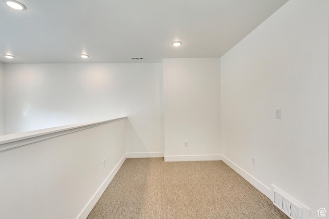 empty room featuring light colored carpet, baseboards, visible vents, and recessed lighting