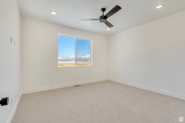 unfurnished room with light carpet, visible vents, baseboards, recessed lighting, and ceiling fan