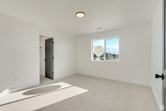 unfurnished room featuring baseboards, visible vents, and light colored carpet