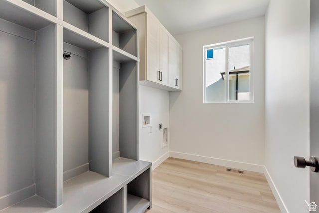 mudroom featuring light wood-type flooring, baseboards, and visible vents