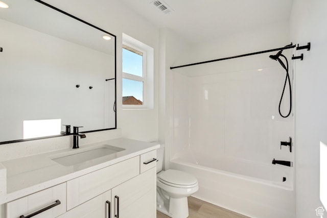 full bathroom featuring toilet, bathtub / shower combination, visible vents, wood finished floors, and vanity