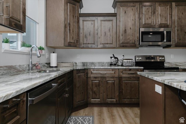 356 W Rendezvous Way, Garden City, UT 84028 - kitchen with light stone counters, dark brown cabinetry, stainless steel appliances, and sink