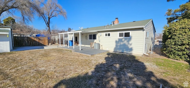 back of house featuring a patio area and a lawn