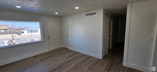 empty room featuring dark hardwood / wood-style floors and a textured ceiling