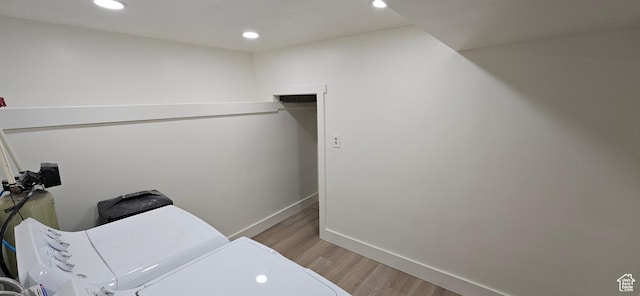 laundry room with washer and dryer and light hardwood / wood-style flooring