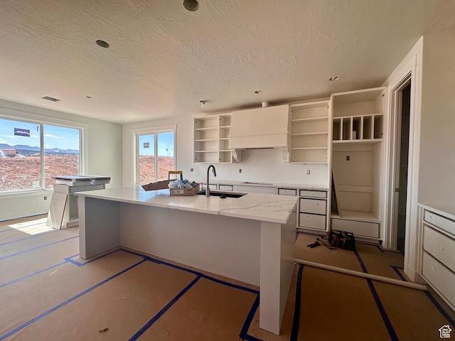 1589 S 4000 W Unit 12, Hurricane, UT 84737 - kitchen featuring open shelves, a sink, a kitchen island with sink, electric stovetop, and a textured ceiling