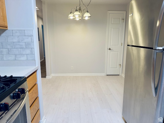 1444 S 430 W Unit 7, Orem, UT 84058 - kitchen with stainless steel appliances, light wood-type flooring, a chandelier, light countertops, and tasteful backsplash