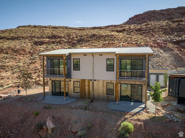 1185 S Murphy Ln Unit 201A, Moab, UT 84532 - back of house featuring a balcony, a patio area, a mountain view, and metal roof