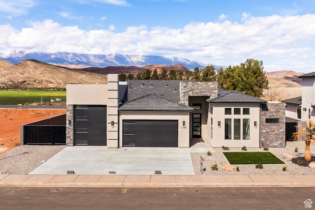 view of front facade with stone siding, stucco siding, an attached garage, and concrete driveway