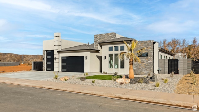 view of front of property featuring stucco siding, an attached garage, concrete driveway, and fence
