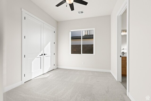 unfurnished bedroom with light carpet, visible vents, ceiling fan, and baseboards