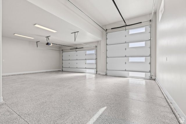 garage featuring a garage door opener and baseboards