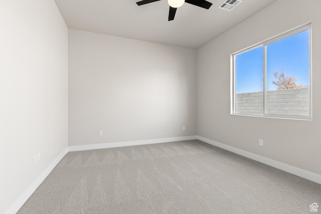 unfurnished room with visible vents, light carpet, baseboards, and a ceiling fan