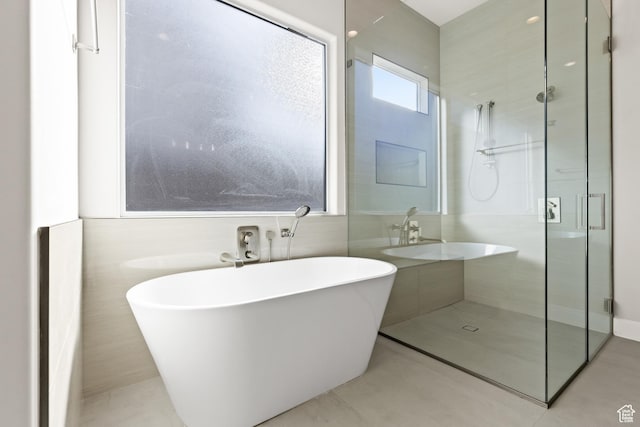 bathroom featuring a freestanding tub and a shower stall