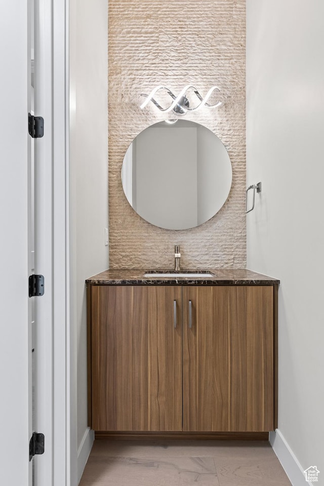bathroom with decorative backsplash, baseboards, and vanity