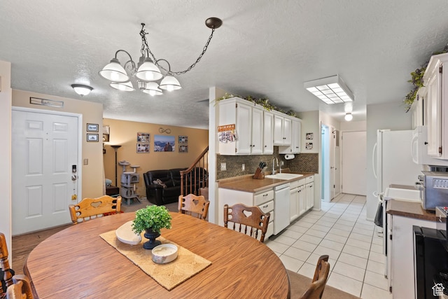 271 Brookfield Ln, Centerville, UT 84014 - dining area featuring a textured ceiling, an inviting chandelier, and light tile patterned floors
