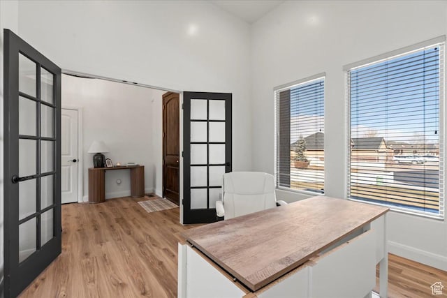 office space with light hardwood / wood-style flooring and french doors