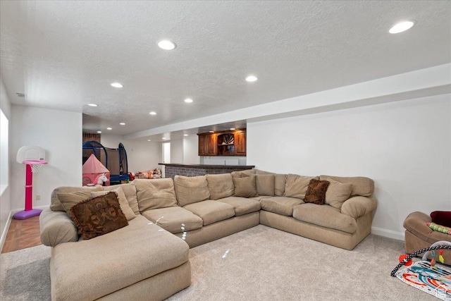 living room featuring light colored carpet and a textured ceiling