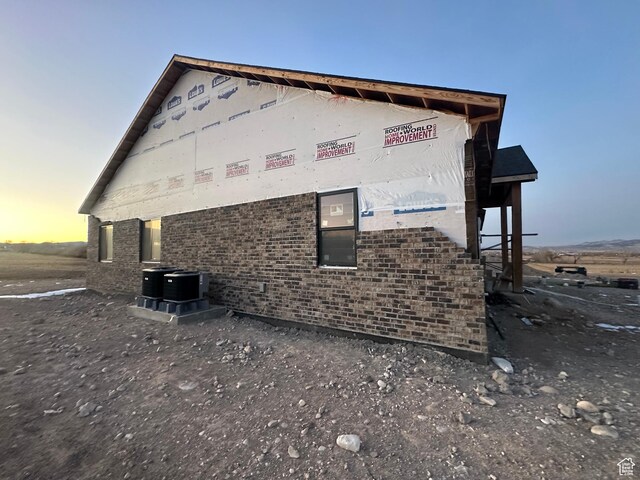 property exterior at dusk with cooling unit