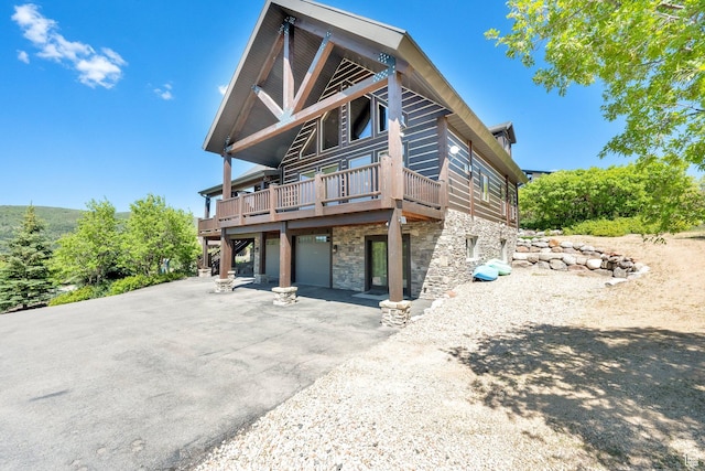 9284 E Tree Top Cir Unit 856, Heber City, UT 84032 - view of front of home featuring stone siding, driveway, a garage, and a wooden deck