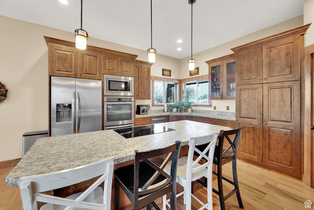 9284 E Tree Top Cir Unit 856, Heber City, UT 84032 - kitchen with appliances with stainless steel finishes, glass insert cabinets, brown cabinets, a breakfast bar area, and recessed lighting