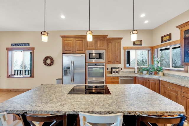 9284 E Tree Top Cir Unit 856, Heber City, UT 84032 - kitchen with stainless steel appliances, a breakfast bar, a kitchen island, recessed lighting, and decorative light fixtures