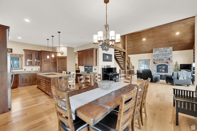 9284 E Tree Top Cir Unit 856, Heber City, UT 84032 - dining space featuring light wood-type flooring, a stone fireplace, recessed lighting, lofted ceiling, and a chandelier