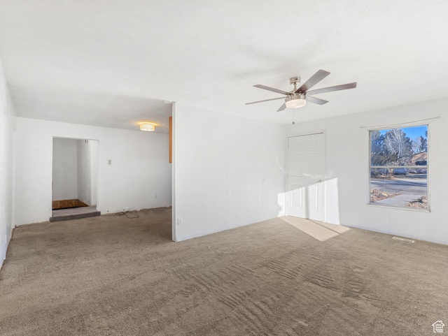 carpeted spare room with ceiling fan