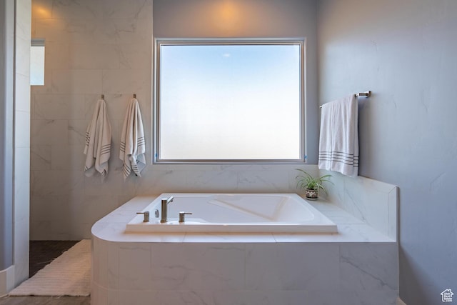bathroom with a relaxing tiled tub