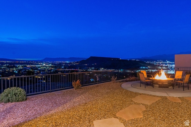 patio at night with an outdoor fire pit and a mountain view