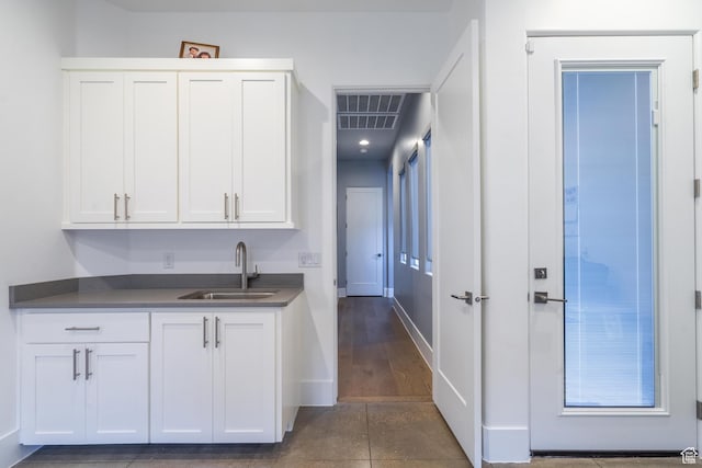 bar featuring sink and white cabinets