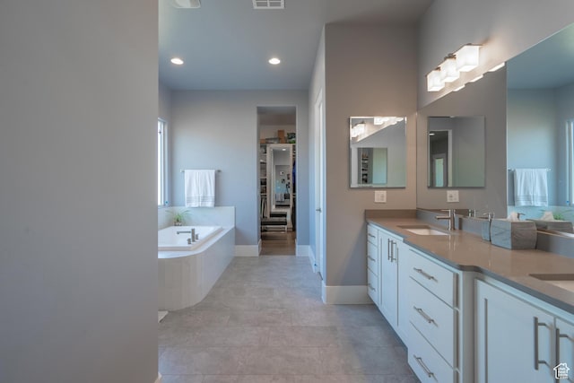 bathroom featuring vanity and a relaxing tiled tub