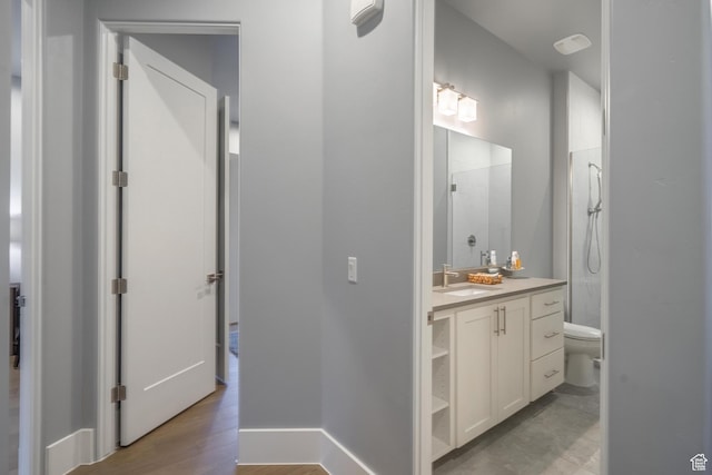 bathroom with vanity, toilet, wood-type flooring, and a shower