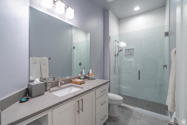 bathroom with vanity, toilet, a shower with shower door, and tile patterned flooring