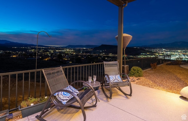 patio terrace at dusk with a balcony and a mountain view