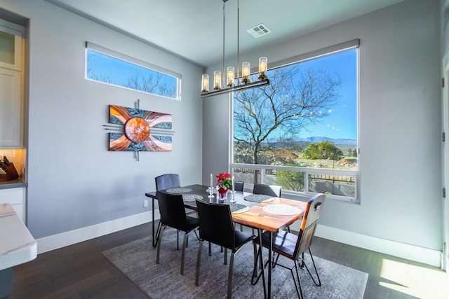 dining space with dark hardwood / wood-style flooring, a chandelier, and a mountain view