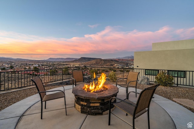 patio terrace at dusk with a mountain view and a fire pit