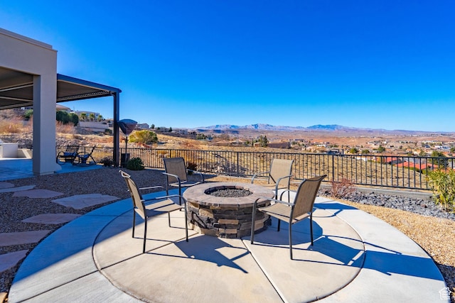 view of patio with a mountain view and a fire pit