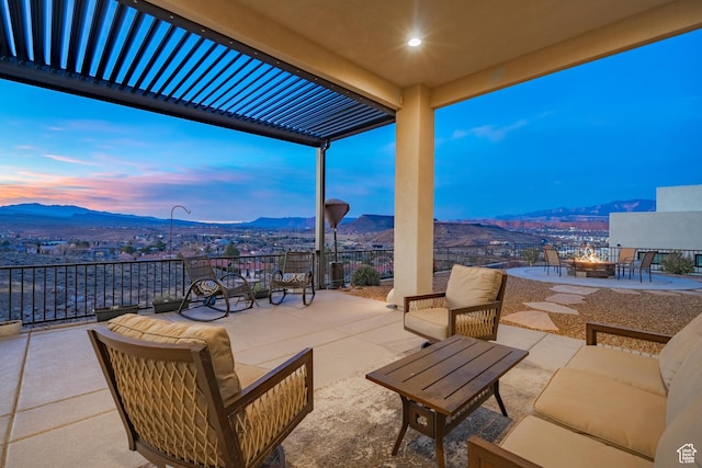 patio terrace at dusk with a mountain view and a fire pit