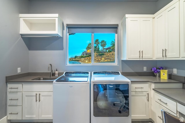 washroom with cabinets, sink, and washer and clothes dryer