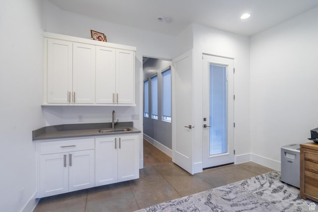 kitchen with white cabinetry, sink, and tile patterned flooring